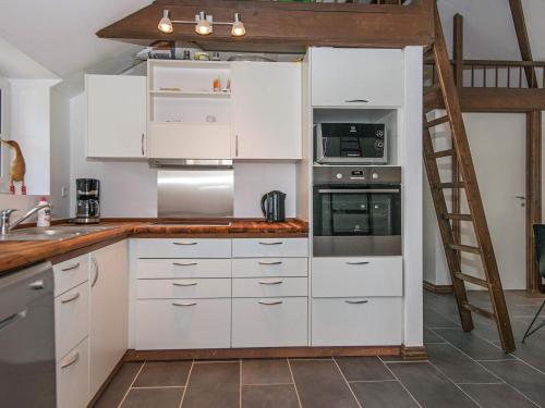 a kitchen with white cabinets and a ladder at 5 star holiday home in Ansager in Ansager