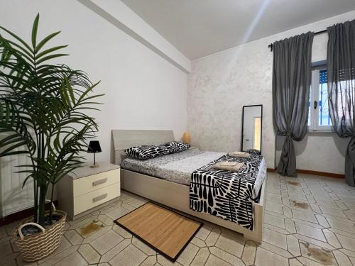 a bedroom with a bed and a potted plant at Oleandri Concept Apartment in Rome