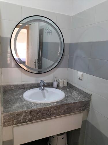 a bathroom with a sink and a mirror at Agadir Best Apparts in Imi Ouaddar