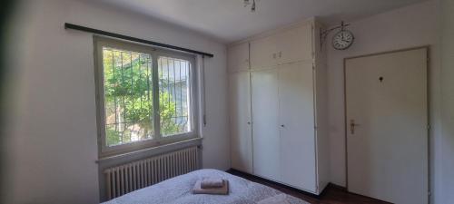 a bedroom with a bed and a window and a door at Doppelzimmer mit Gemeinschaftsbad - und Küche in Purasca