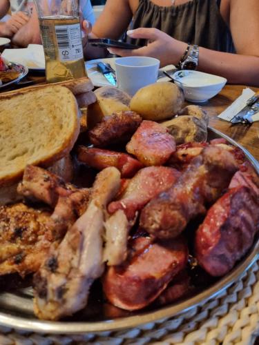 a plate of food with meat and bread on a table at Belvedere La Cristina in Corbeni