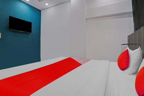 a bedroom with a red and white bed and a tv at Hotel O Elite Inn in Delhi