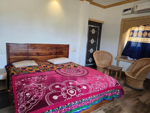 a bedroom with a bed with a red bedspread at Burj Al Jaisalmer Luxury Desert Camp in Sām