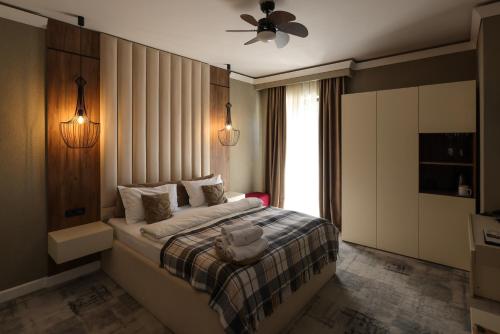 a bedroom with a bed with a ceiling fan and a window at Elexus Boutique in Predeal