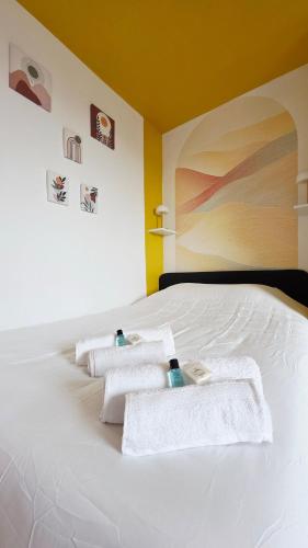 a white bed with towels on top of it at Le Citadel - Centre et Quais in Dunkerque