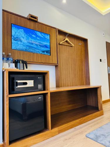 a living room with a tv and a microwave at Hotel Harsha Nepal in Kathmandu