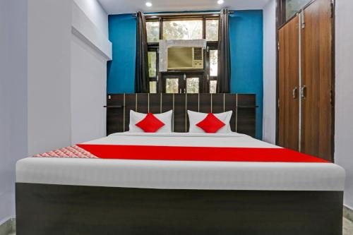 a bedroom with a large bed with red pillows at Hotel O Elite Inn in Delhi