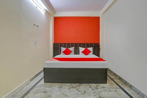 a bedroom with a bed with red pillows at Hotel O Elite Inn in Delhi