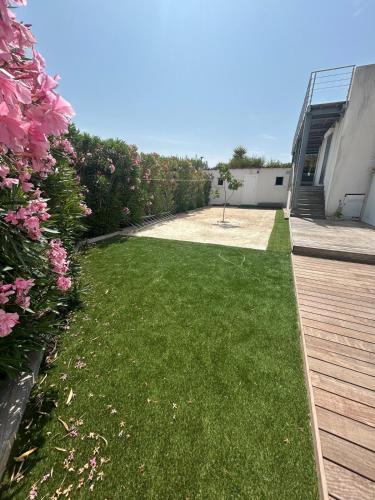a yard with green grass and pink flowers at Vue incroyable sur la baie de La Ciotat in La Ciotat