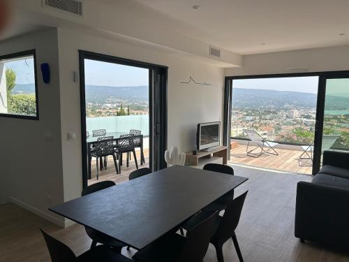 a living room with a table and chairs and a view at Vue incroyable sur la baie de La Ciotat in La Ciotat