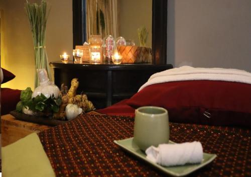 a table with a plate of food and a cup on it at Angkor Land House in Phumĭ Réach Born