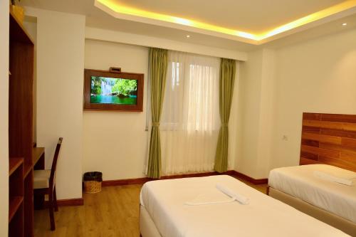a hotel room with two beds and a window at Hotel Harsha Nepal in Kathmandu