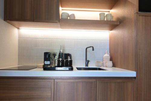 a kitchen with a sink and a counter top at Nozol Al Rayaheen By Sharjah Collection in Khor Fakkan