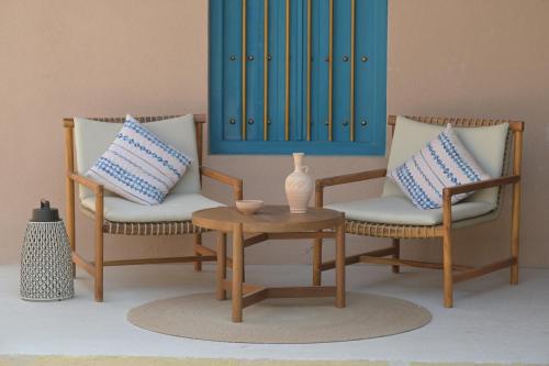 a living room with two chairs and a table at Nozol Al Rayaheen By Sharjah Collection in Khor Fakkan