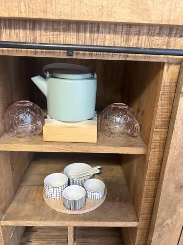 a wooden shelf with bowls and a blue bowl at Neues Apartment bei Heidelberg in Leimen