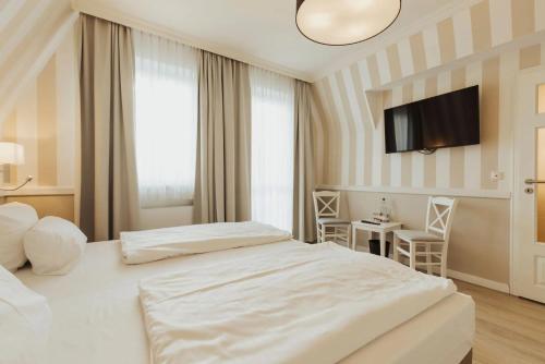 una camera da letto con due letti e una TV a schermo piatto di Villa Strandperle IV Jahreszeiten Kühlungsborn a Kühlungsborn