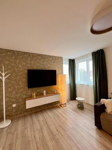 a living room with a flat screen tv on a wall at The Blackbridge Apartment in Sárvár