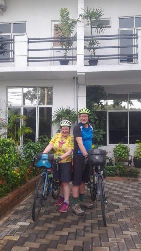 two people standing with their bikes in front of a building at Airport 4 Season Transit Hotel in Katunayake