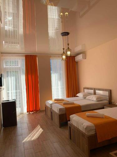 a hotel room with three beds and windows at Villa Oranji in Itʼkhvisi