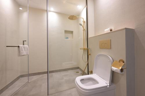 a bathroom with a toilet and a glass shower at Nozol Al Rayaheen By Sharjah Collection in Khor Fakkan