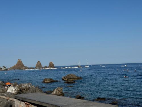 a body of water with rocks and boats in it at Almarèa, a un passo dal mare in Aci Castello