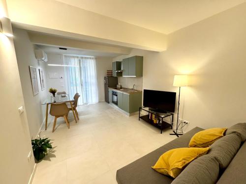 a living room with a couch and a kitchen at Almarèa, a un passo dal mare in Aci Castello