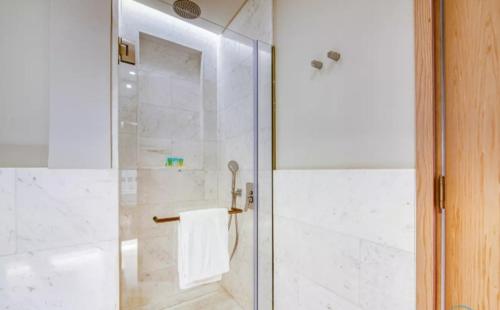a shower with a glass door with a towel at Palm Tower Palm Jumeirah Dubai in Dubai