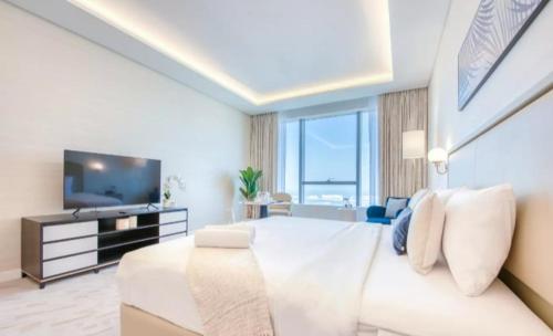 a large white room with a large bed and a television at Palm Tower Palm Jumeirah Dubai in Dubai