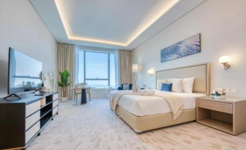 a large bedroom with a large bed and a television at Palm Tower Palm Jumeirah Dubai in Dubai
