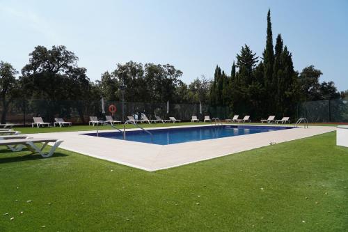 a large swimming pool with chairs in the grass at Hostal Rural Can Pau in Cantallops