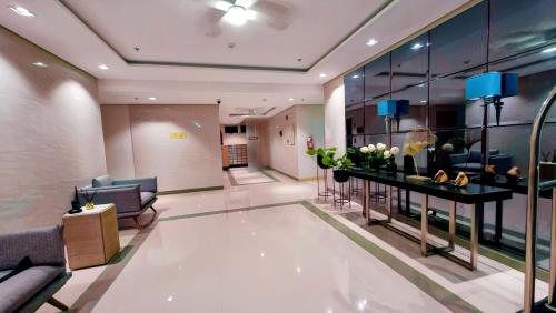 a lobby with couches and a table with flowers at SMDC PARK RESIDENCE SM City Santa Rosa, Laguna in Ibaba