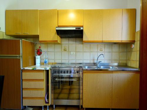 a kitchen with wooden cabinets and a stove and a sink at Sunlit home with pool in Fucecchio
