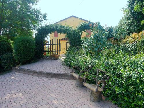 a garden with a gate and two benches and bushes at Sunlit home with pool in Fucecchio