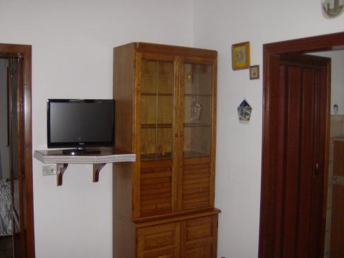 a wooden cabinet with a television in a room at Sunlit home with pool in Fucecchio