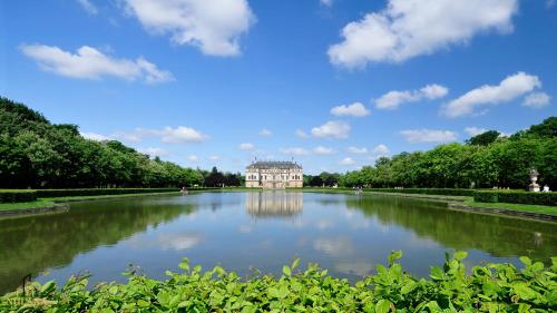Blick auf einen See mit einem Gebäude in der Ferne in der Unterkunft Royal Garden Residence in Dresden