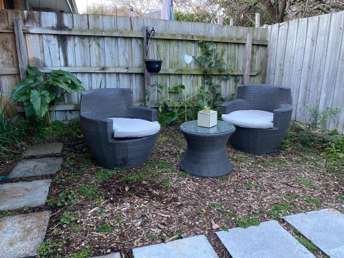 three wicker chairs and toilets in a backyard at Zen Rye Unit in Rye