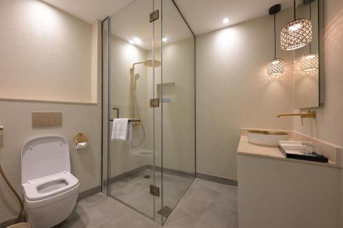 a bathroom with a toilet and a glass shower at Nozol Al Rayaheen By Sharjah Collection in Khor Fakkan