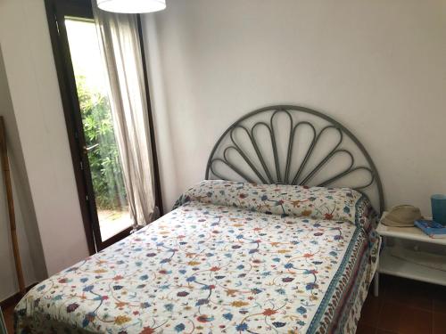 a bedroom with a bed with a quilt on it at Villetta Simius Luxury in Simius