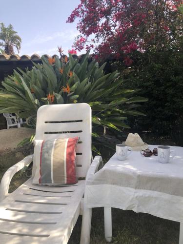 a white chair with a pillow and a table at Villetta Simius Luxury in Simius