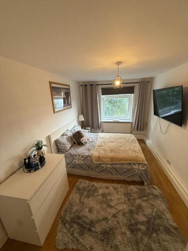 Un dormitorio con dos camas y una ventana. en Charming Family Flat 1 Bedroom, en Norwood
