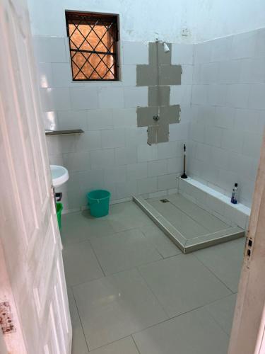 a bathroom with a tub and a tiled floor at Samira House in Mombasa