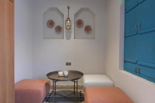 a small table and two stools in a room at Nozol Al Rayaheen By Sharjah Collection in Khor Fakkan