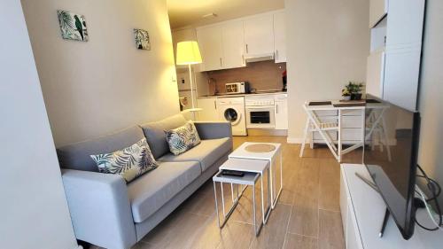 a living room with a couch and a kitchen at Parque Playa II in Gijón