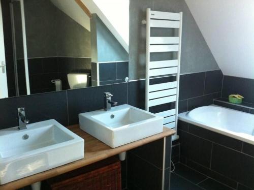 une salle de bains avec lavabo, miroir et baignoire dans l'établissement Villa moderne à 200m de la mer avec jardin clos, à Saint-Vaast-la-Hougue