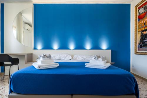 a blue bedroom with a bed with towels on it at Centoquaranta Apartment in Terrasini