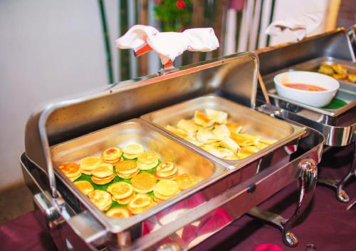 a buffet with a tray of food on a table at Angkor Land House in Phumĭ Réach Born