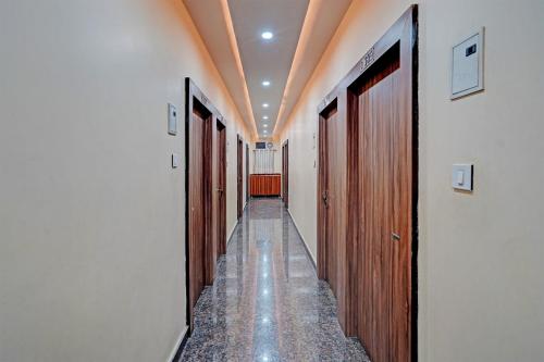 a hallway with many wooden doors and a hallwayngth at Hotel O MVD Inn Gomti Nagar in Lucknow