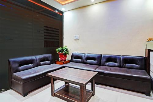 a living room with a couch and a table at Hotel O MVD Inn Gomti Nagar in Lucknow