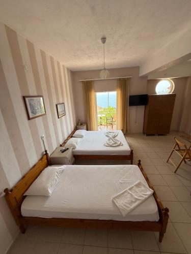 a room with three beds and a window at Emilios house in Dhërmi