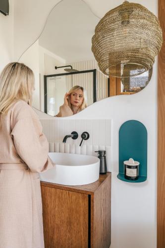 a woman standing in front of a sink in a bathroom at Polna Mięta in Stronie Śląskie